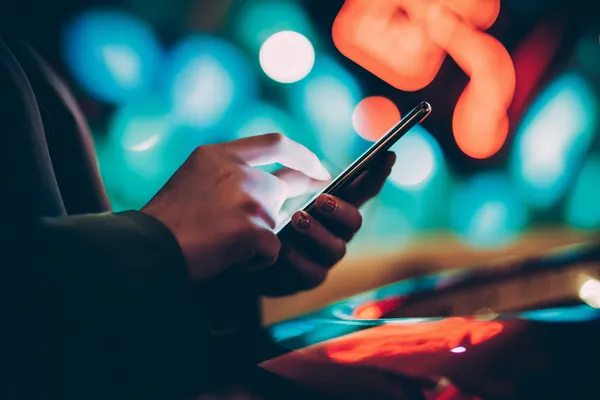 A glamorous woman holding casino chips in a neon-lit environment, representing the premium online casino atmosphere of 47777.