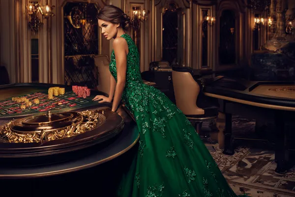 A woman in a luxurious green gown next to an ornate roulette wheel, capturing the upscale casino mood of 47777.
